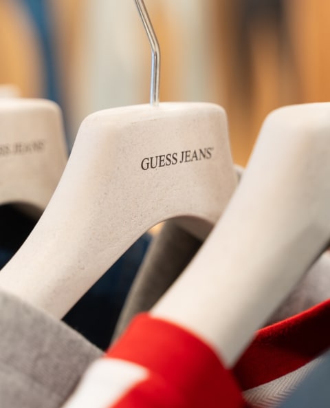 Image of a GUESS Jeans hanger made from biodegradable and recycled materials.
